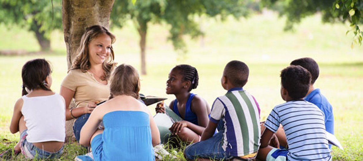 Eine multikulturelle Gruppe lernt unter einem Baum