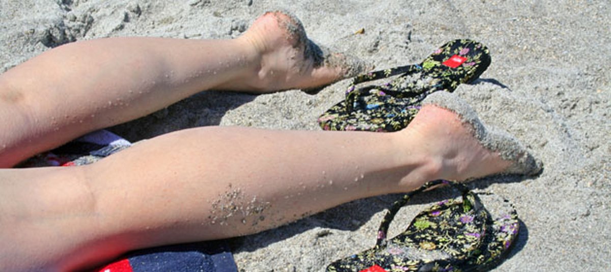 Beine ausgestreckt im Sand