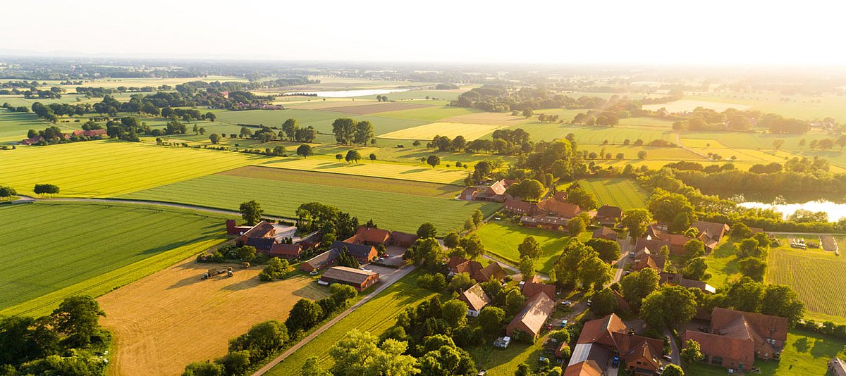 Ein Luftaufnahme eines kleinen Dorfes von Feldern umgeben.