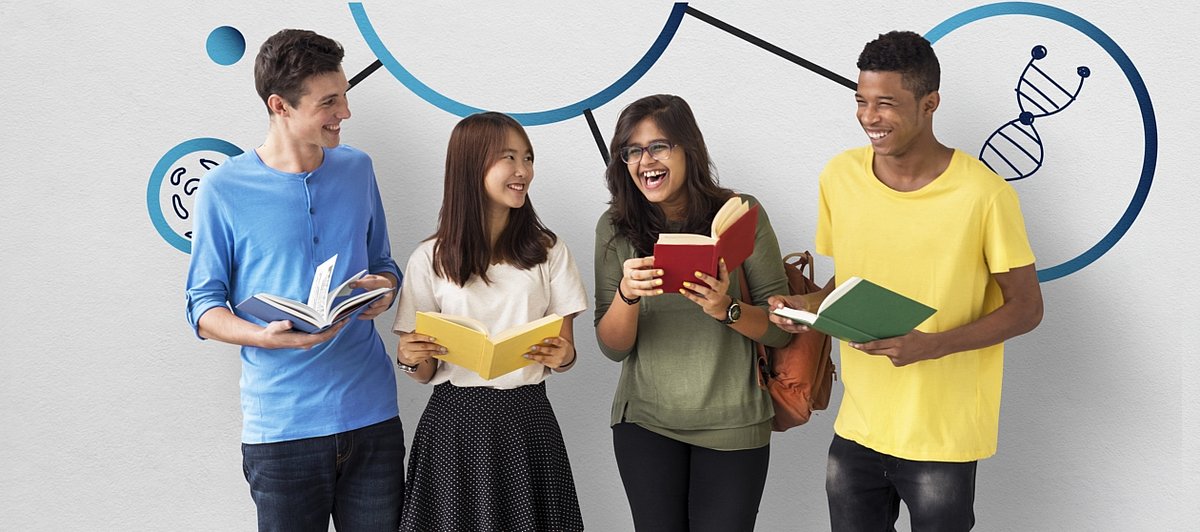Vier Jugendliche stehen nebeneinander, lachen und halten Lehrbücher in den Händen