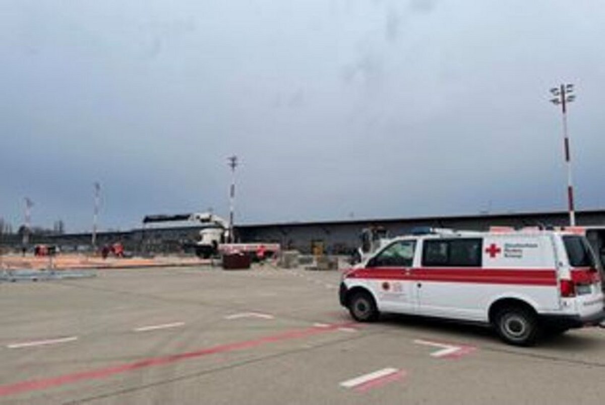Aufbau eines Großzeltes am ehemaligen Flughafen Berlin Tegel. Rechts im Vordergrund steht ein Fahrzeug des Deutschen Roten Kreuz.