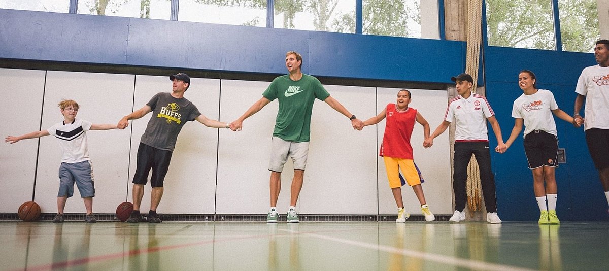 Dirk Nowitzki mit Kindern und Jugendlichen in einer Sporthalle