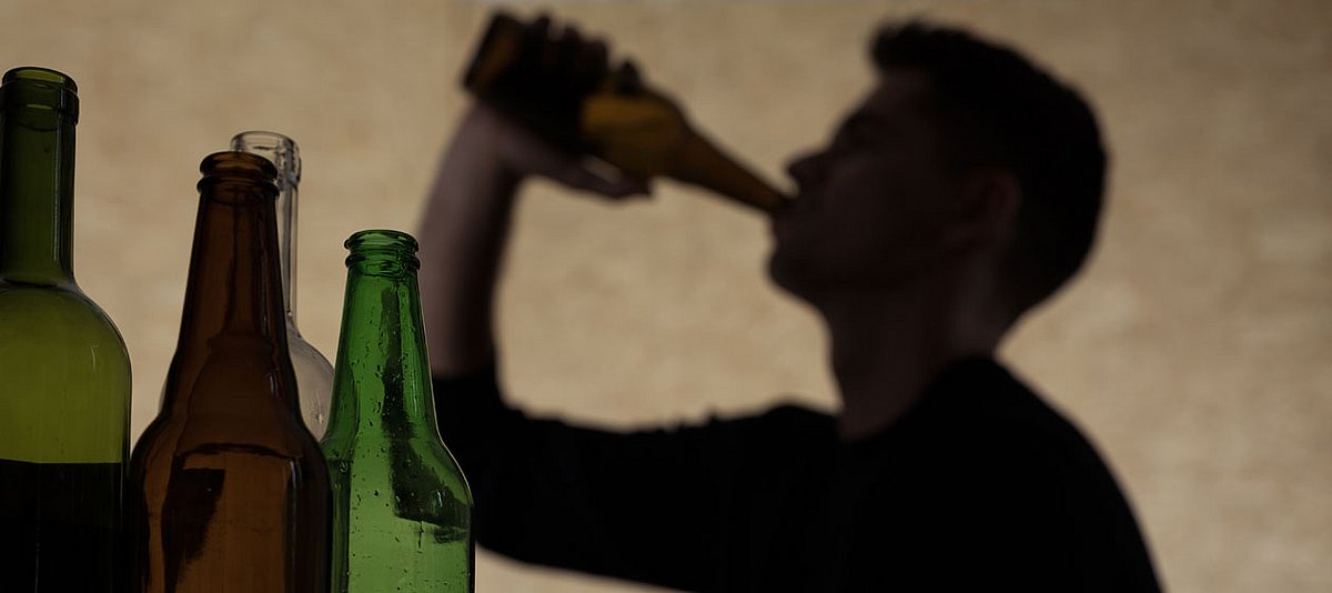 Ein junger Mann trinkt aus einer Bierflasche.