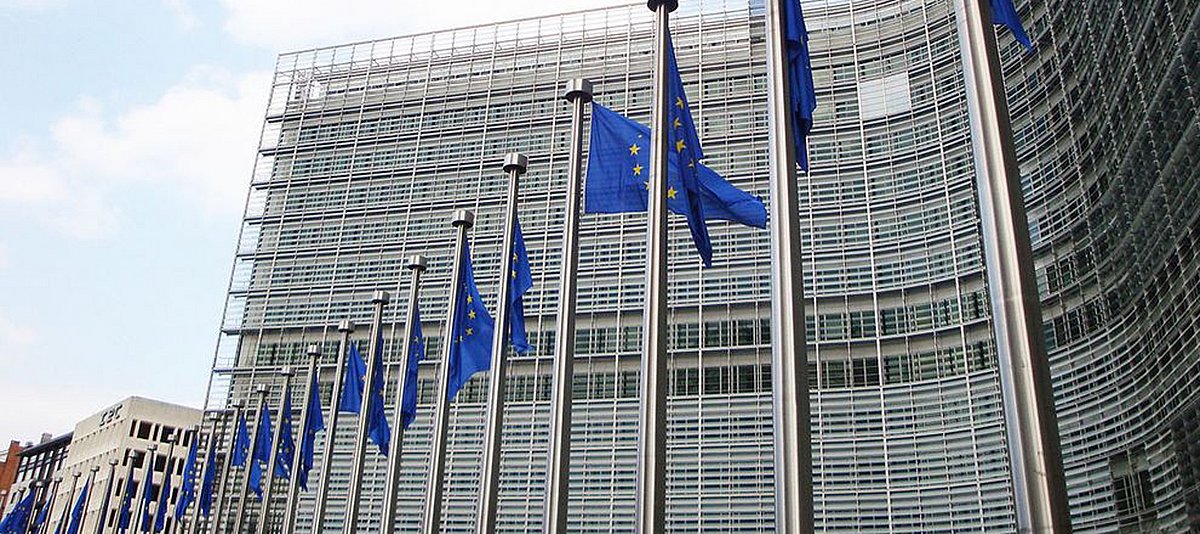 Eine lange Reihe Europafahnen an Fahnenmasten vor dem Dienstgebäude der Europäischen Kommission in Brüssel. 