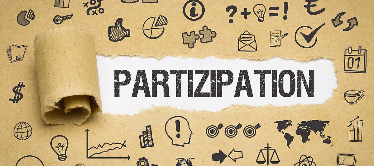 Unterschiedliche Symbole sind auf Packpapier abgebildet und in einem ausgerissenen Streifen steht das Wort Partizipation.