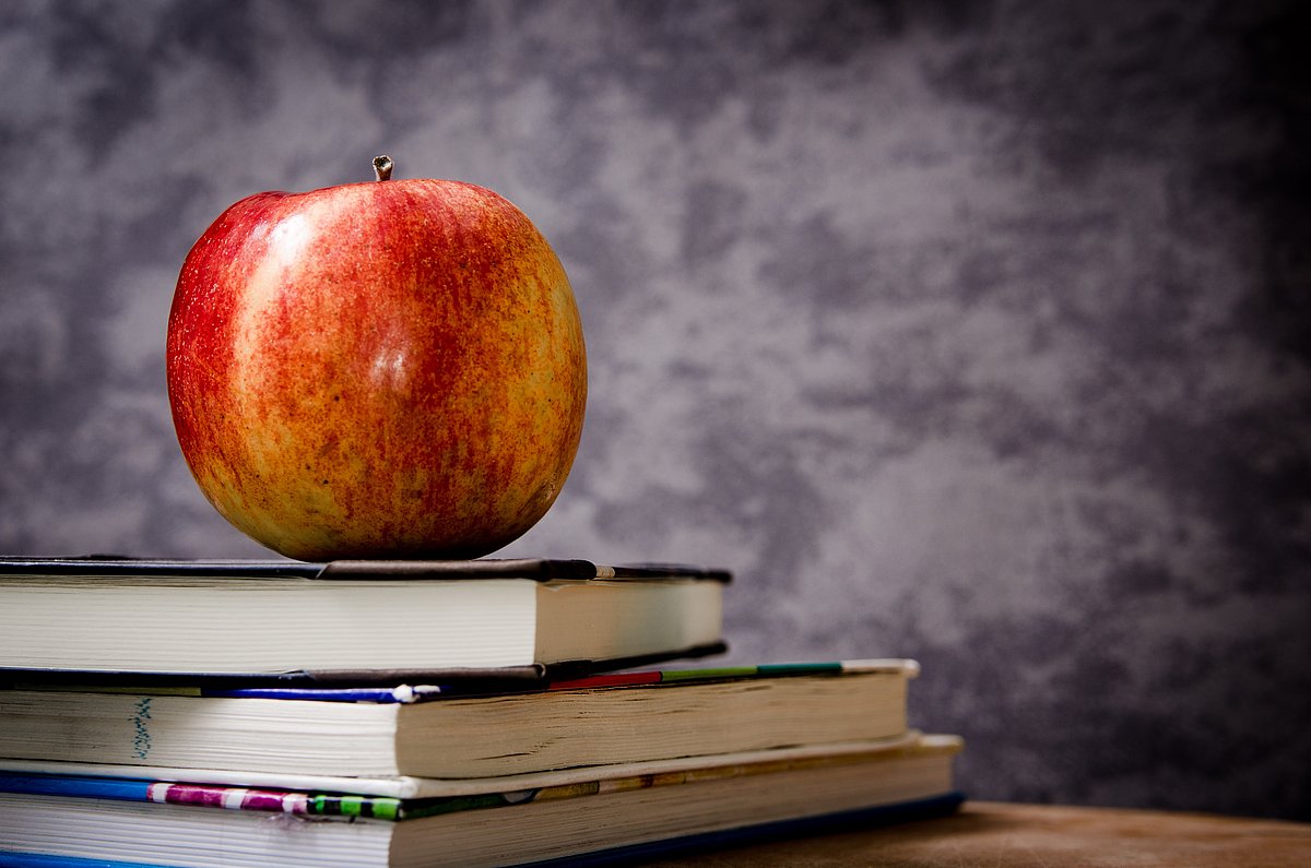 Schulbücher und ein Apfel