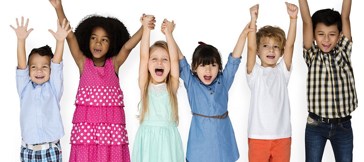 Sechs Kinder halten ihre Arme vor Freude ganz hoch in die Luft