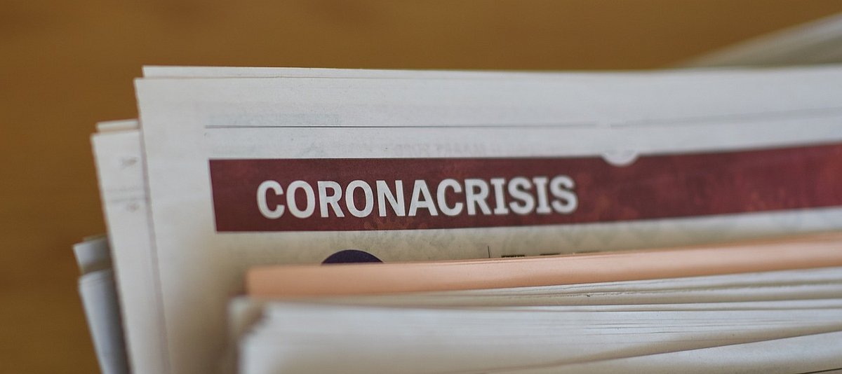 Angeschnittenes Zeitungsbündel mit Überschrift Coronacrisis