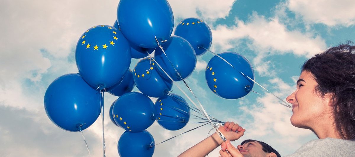 Jugendliche lassen blaue Luftballons in den Himmel aufsteigen 