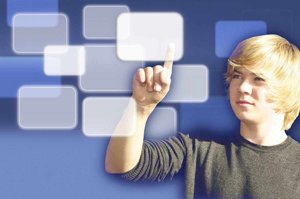 Jugendlicher zeigt auf Sprechblasen eines Touchscreens