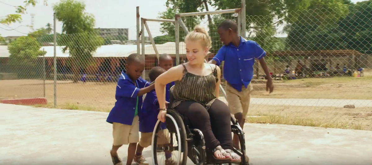 Eine Freiwillige im Rollstuhl spielt mit Kindern in Ghana.