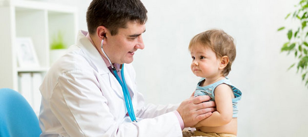 Ein Kinderarzt untersucht ein Kleinkind mit dem Stethoskop