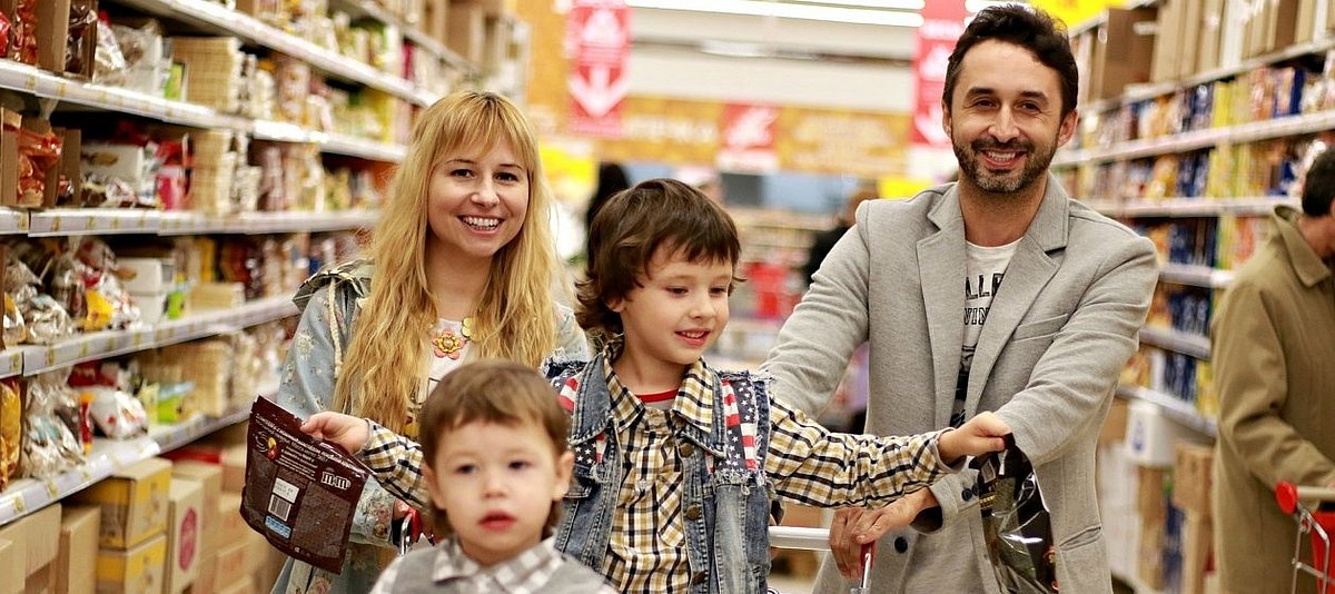 Eine Familie mit zwei Kindern geht einkaufen in einem Supermarkt