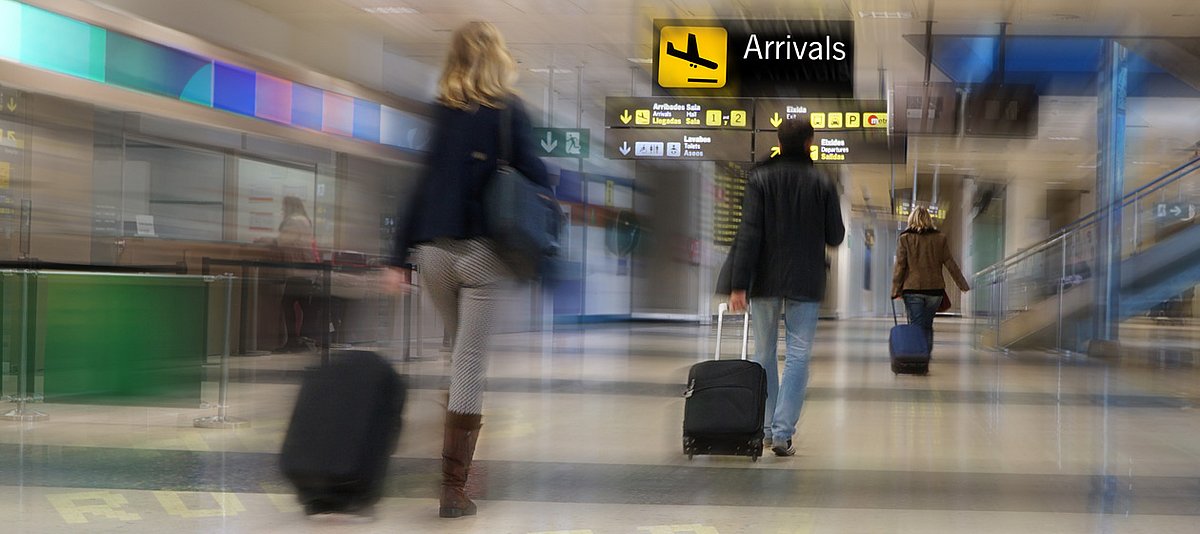 Passagiere ziehen Koffer am Flughafen