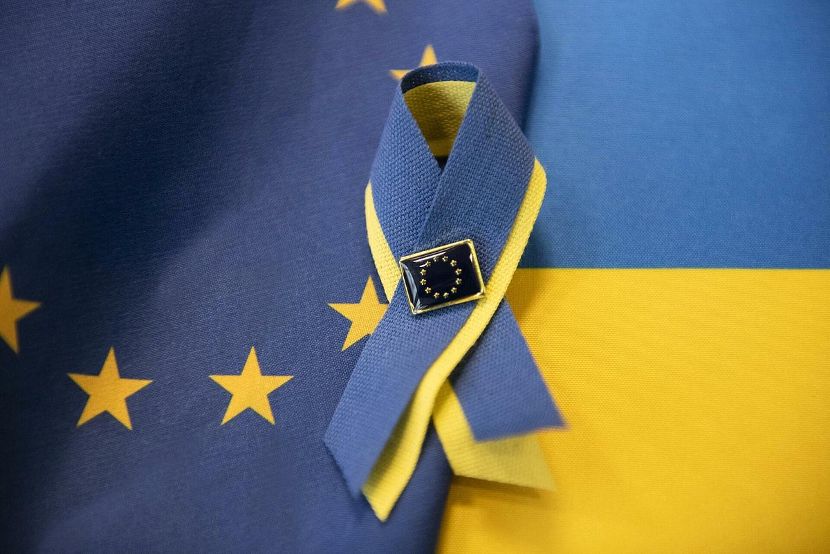 Die ukrainische und europäische Flagge mit einer Solidaritätsschleife vebunden.