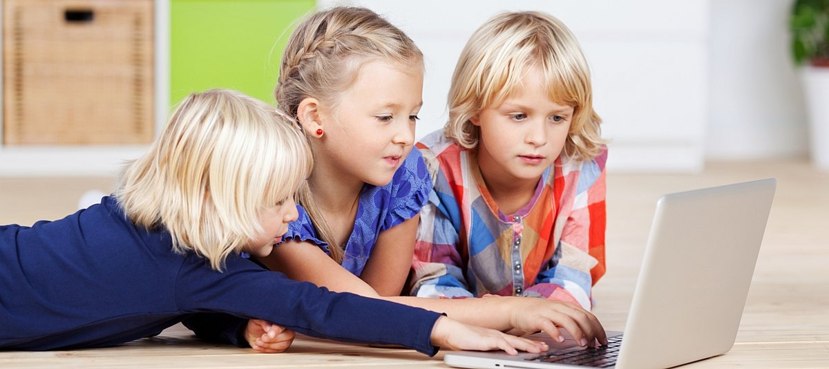 Drei Mädchen mit Laptop im Kinderzimmer