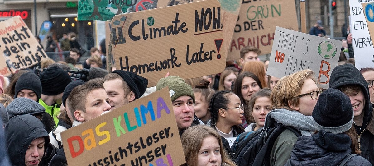 Junge Protestierende mit Schildern zum Klima- und Umweltschutz