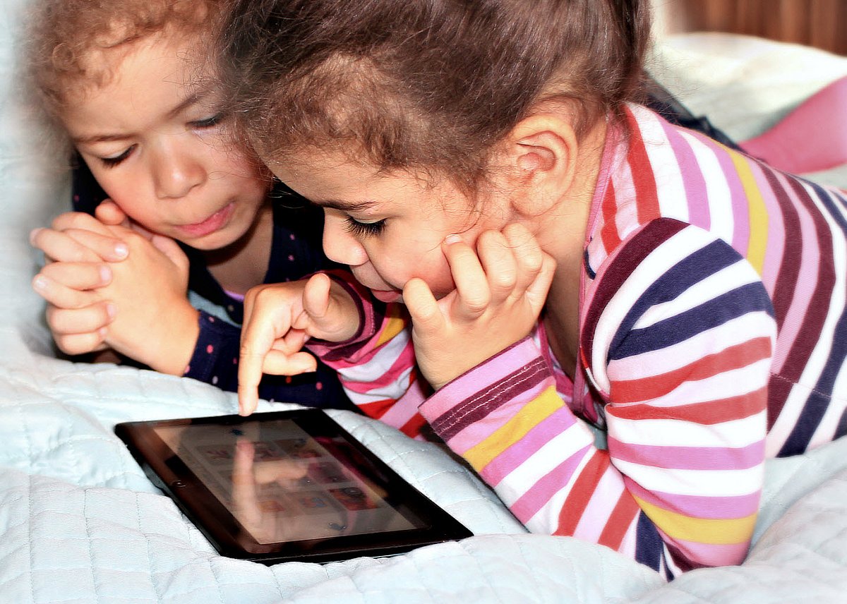 Zwei kleine Mädchen spielen mit einem Tablet-PC