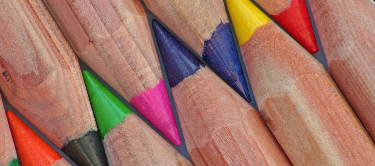 Buntstifte unterschiedlicher Farben liegen eng aneinander