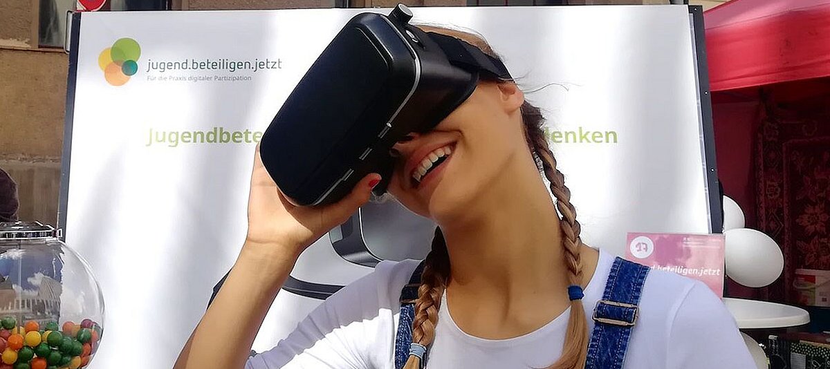 Eine junge Frau mit VR-Brille am Stand des Gemeinschaftsprojekts jugend.beteiligen.jetzt 