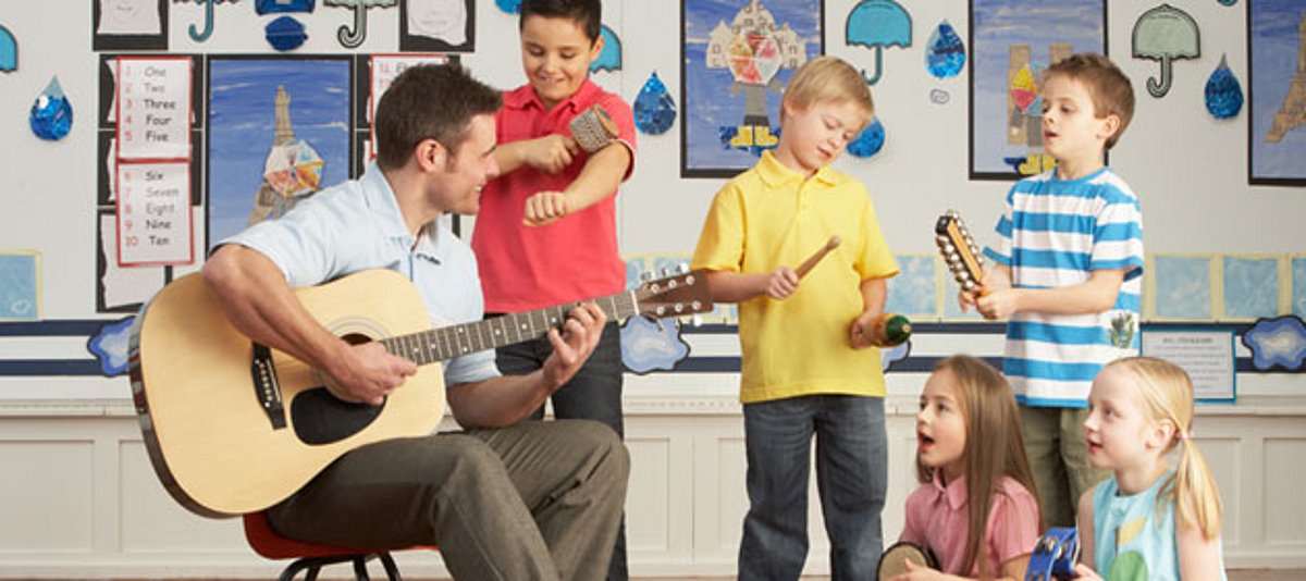 Eine Gruppe Kinder musiziert mit einem Lehrer