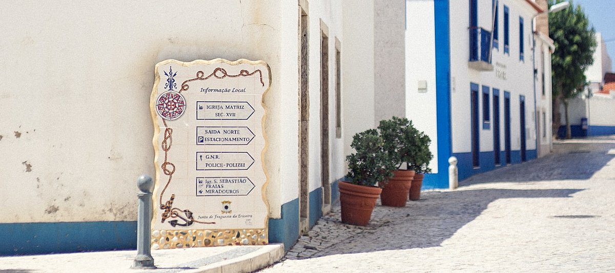 Gebäude und ein Wegweiser in einem portugiesischen Dorf