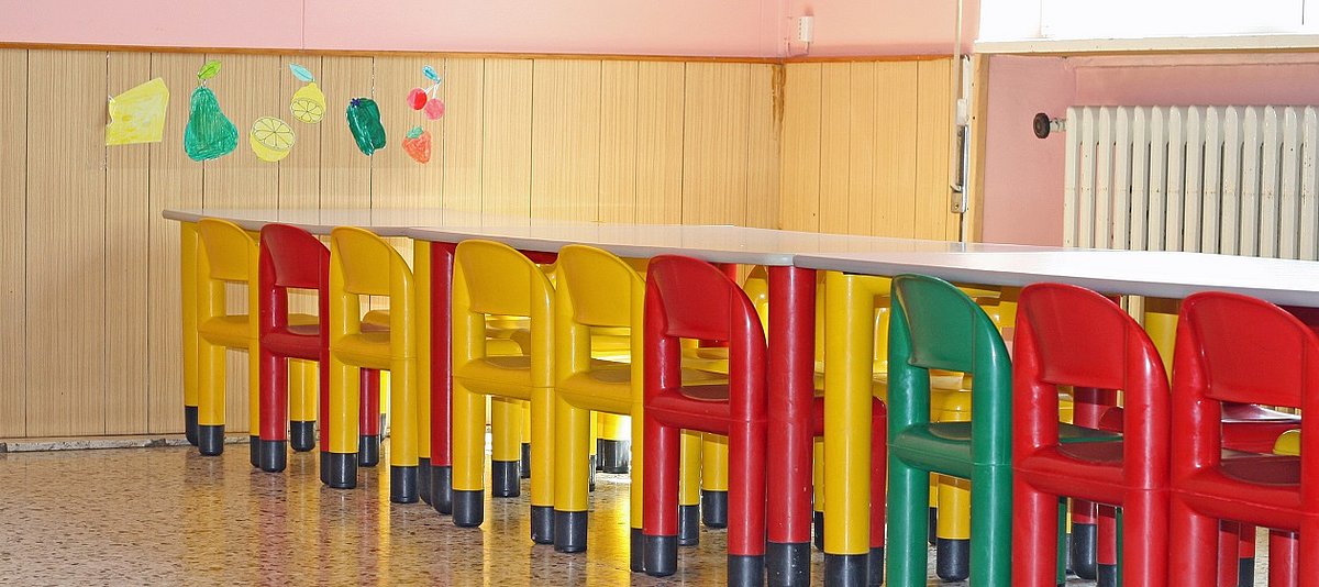 bunte Stühle für Kinder stehen an einem Tisch