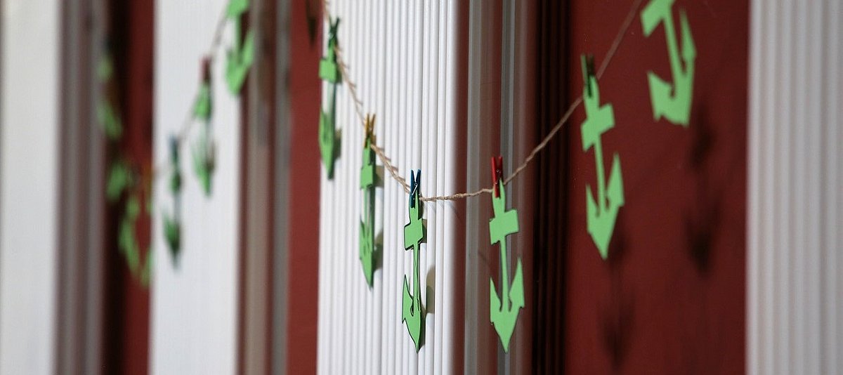 Grüne Anker aus Papier hängen an einer Girlande