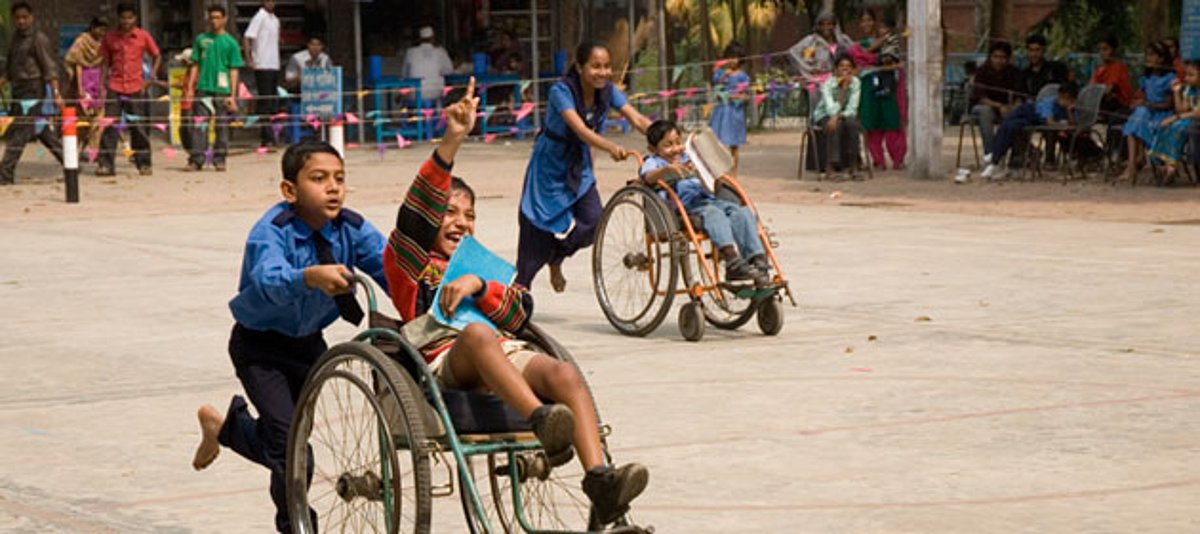 Kinder bei einem Rollstuhlrennen auf einem Schulfest in Bangladesch.