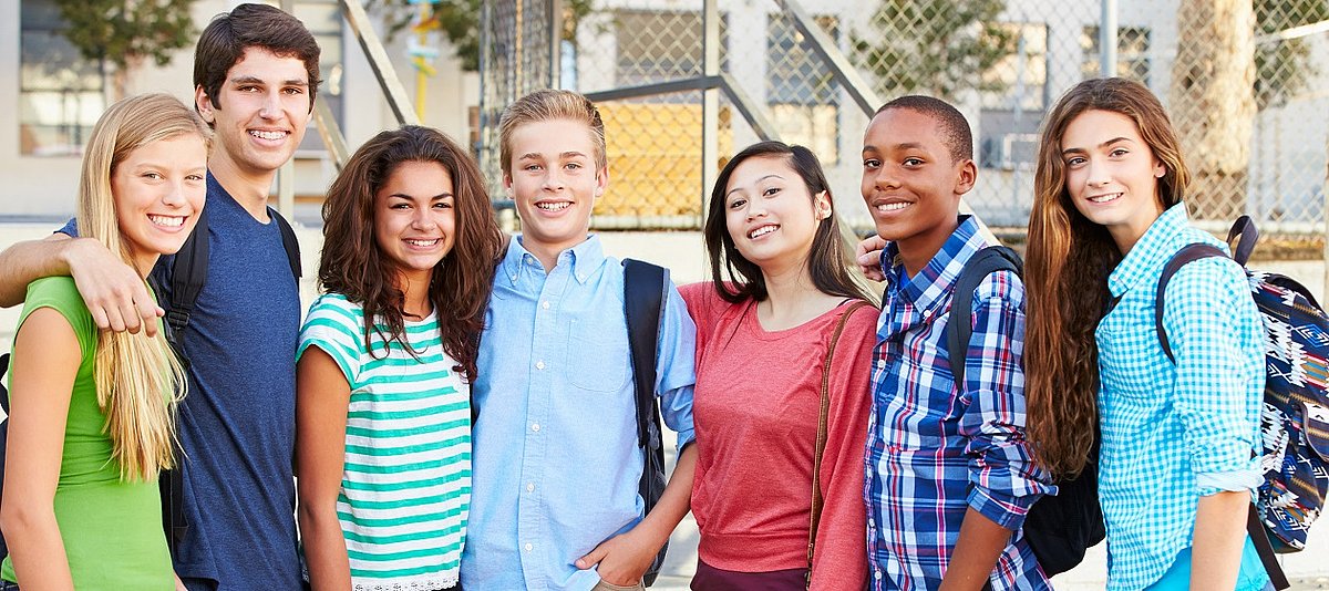 Sieben multikulturelle Jugendliche zeigen sich freundschaftlich