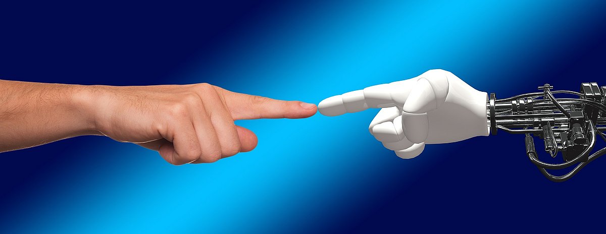 Eine Menschenhand und eine Roboterhand berühren sich mit einem Finger