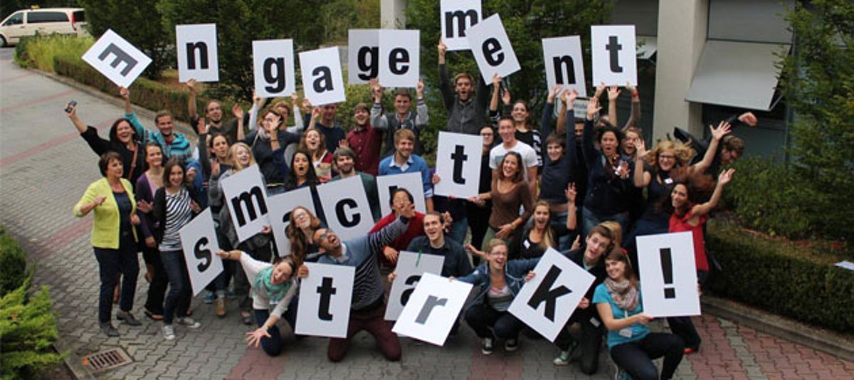 Teilnehmerinnen und Teilnehmer der Civil Academy 2014 halten Buchstaben mit der Aufschrift "Engagement macht stark" hoch