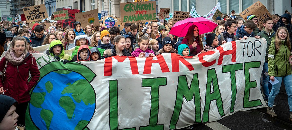 Kinder und Jugendliche mit Plakaten und Bannern demonstrieren bei Fridays for Future