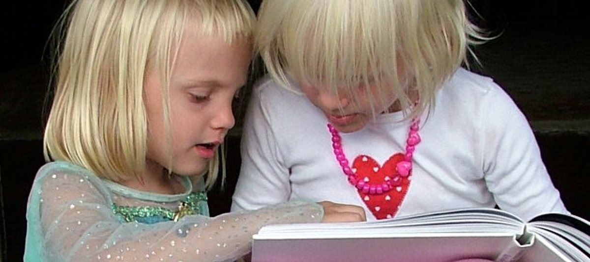 Zwei Kinder schauen zusammen in ein Buch