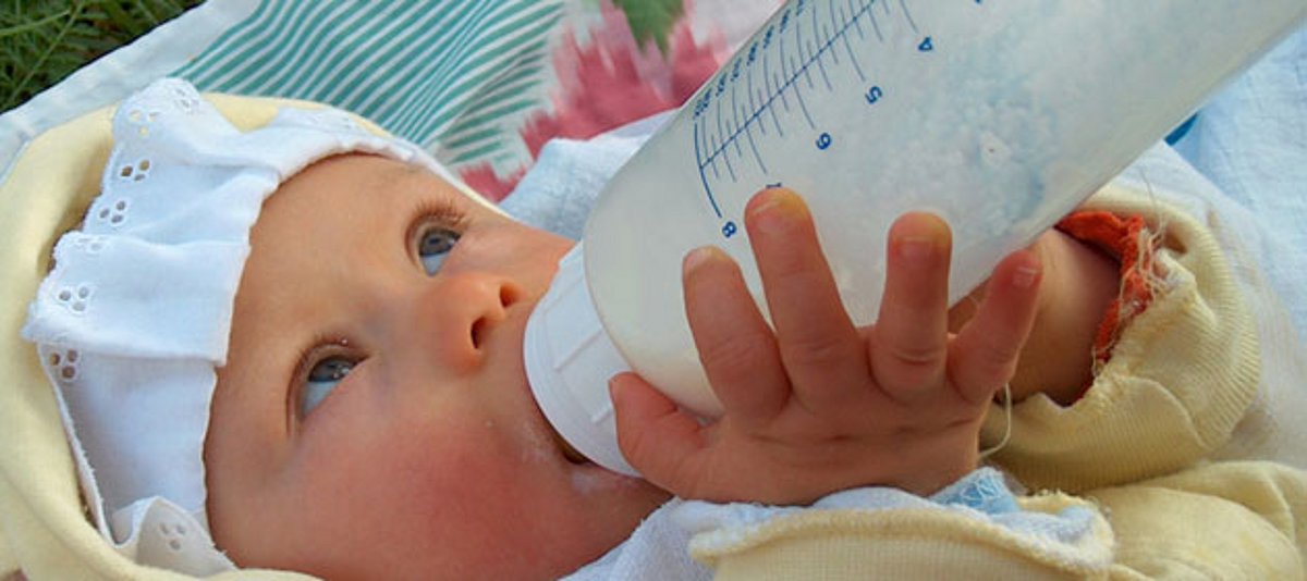 Baby trinkt an einer Milchflasche