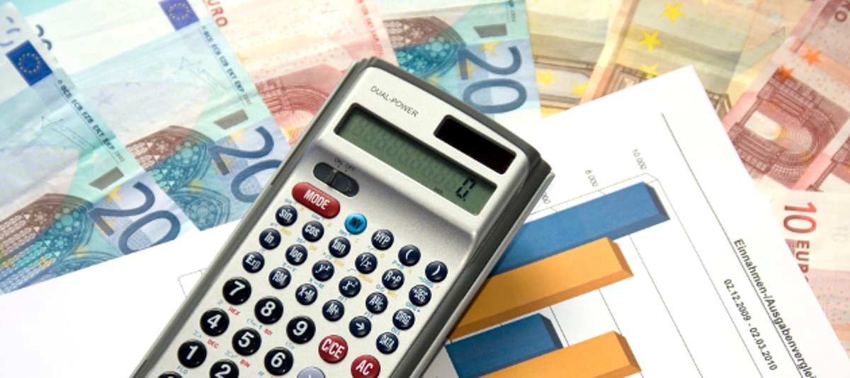 Das Bild zeigt Tabellen, Geldscheine und einen Taschenrechner.