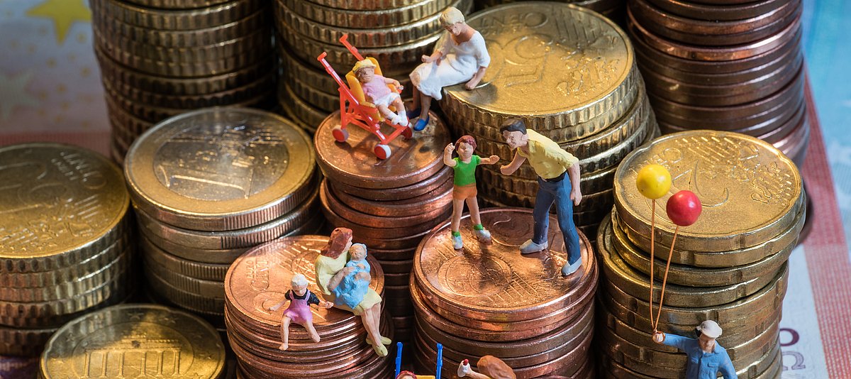 Kleinfamilien auf gestapelten Euromünzen