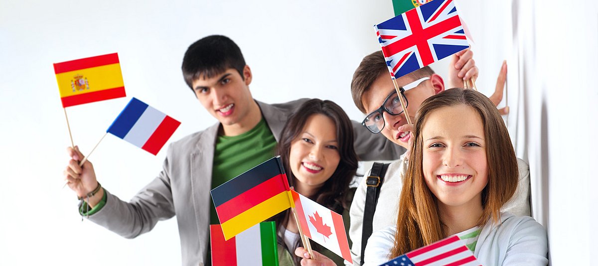 Junge Menschen halten Fahnen unterschiedlicher Nationalitäten