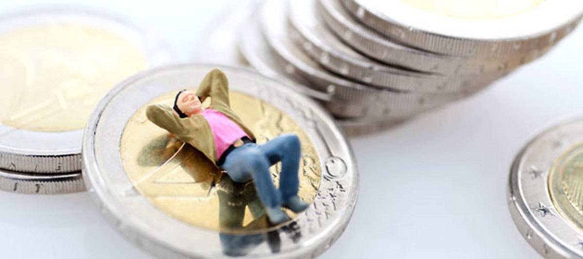 Ein Mann ruht sich auf einer Euro-Münze aus