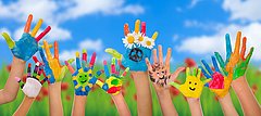 Viele bunt angemalte Kinderhände zeigen in die Luft