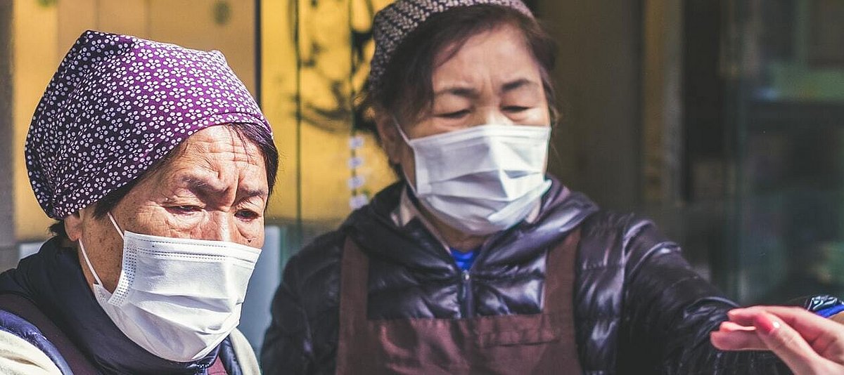 Zwei Frauen mit Mund-Nasen-Schutz auf einem Markt.
