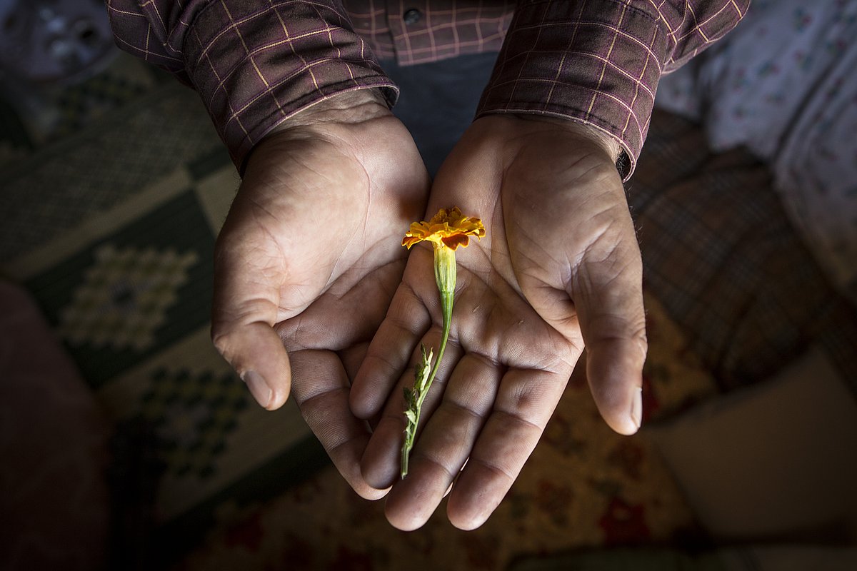 Vater Za'ahir hält Blume in der Hand, die sein in Syrien getötetes 6jähriges Kindes symbolisiert