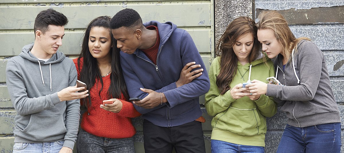 Jugendliche zeigen sich gegenseitig Dinge auf dem Smartphone