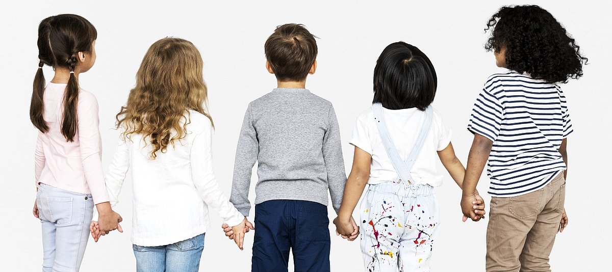 Fünf Kinder, die sich an den Händen halten, stehen mit dem Rücken zum Betrachtenden