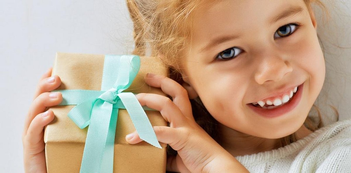 Ein junges Mädchen mit einem kleinen Geschenkpaket in den Händen