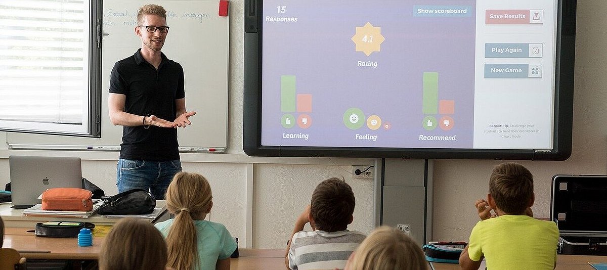Ein Lehrer unterrichtet seine Schulklasse mit Laptop und Whiteboard
