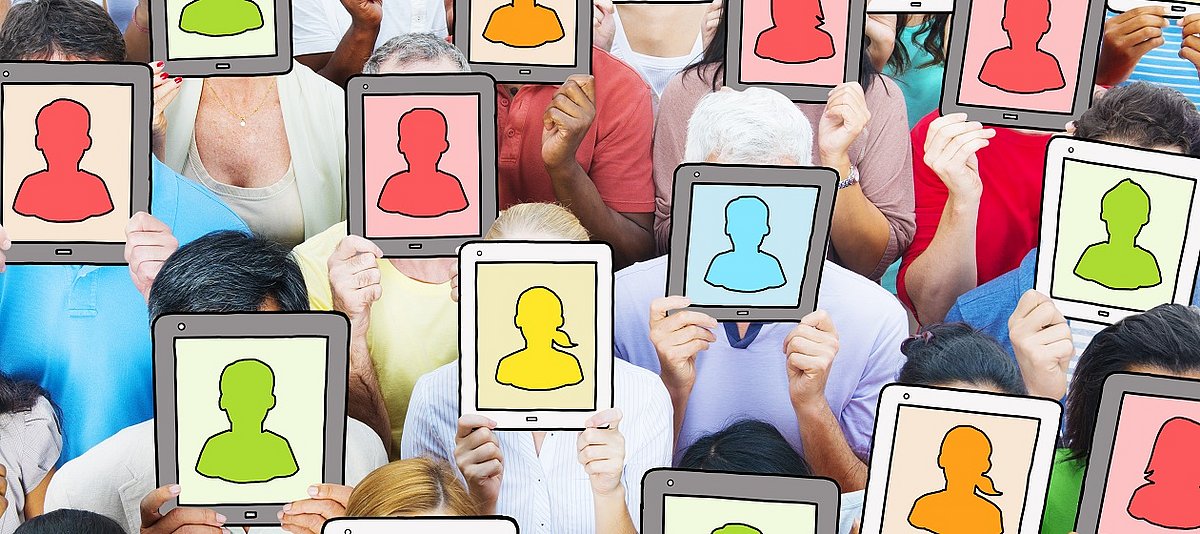 Eine Gruppe von Menschen hält sich Computer-Tablets vor das Gesicht. Darauf zu sehen sind anonyme Gesichter.