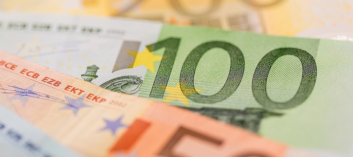 Drei Euro-Geldscheine in hohem Wert liegen aufgefächert am Boden.