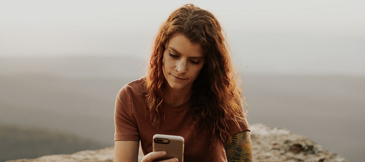 Eine junge Frau schaut auf ihr Smartphone