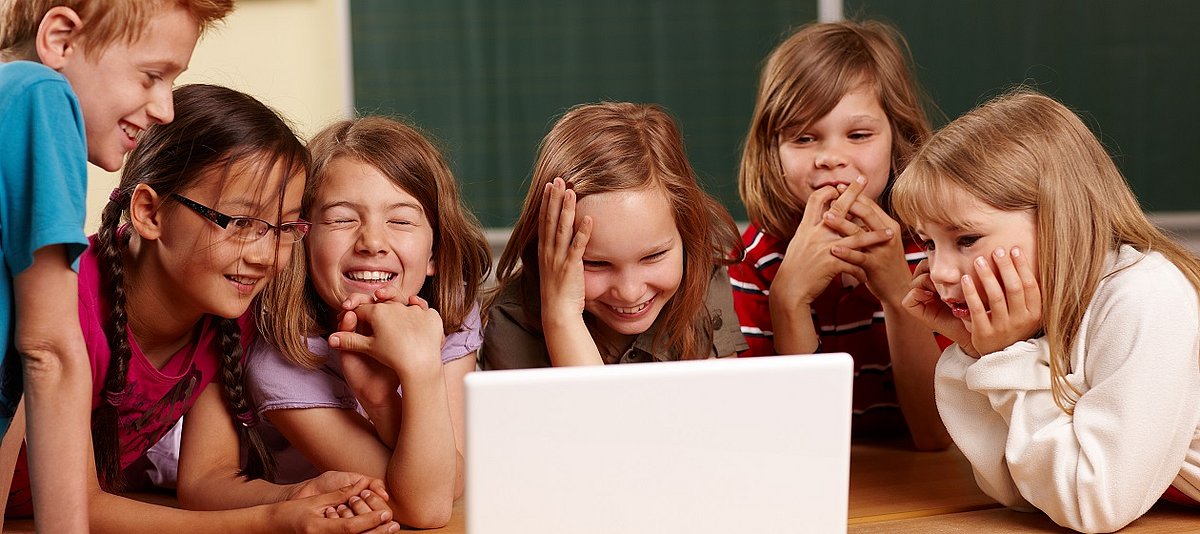 Eine Gruppe von Kindern sitzt vor einem Computer